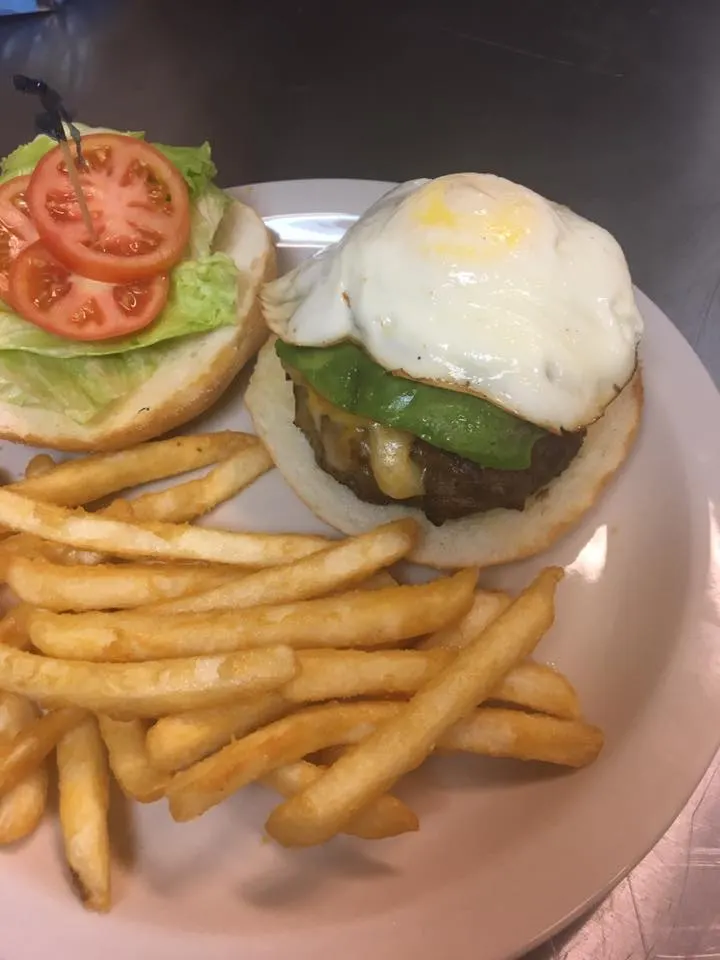 A burger with a fried egg and French fries